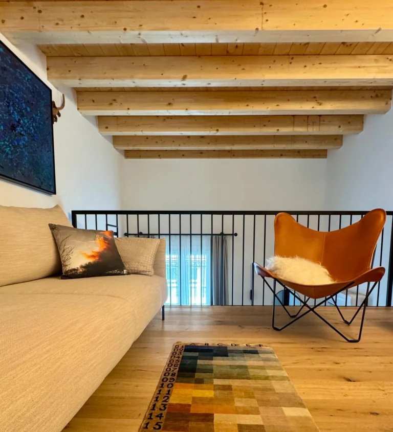 A Cuero Design butterfly chair joins soft seating and layered textures to create an inviting mezzanine lounge.