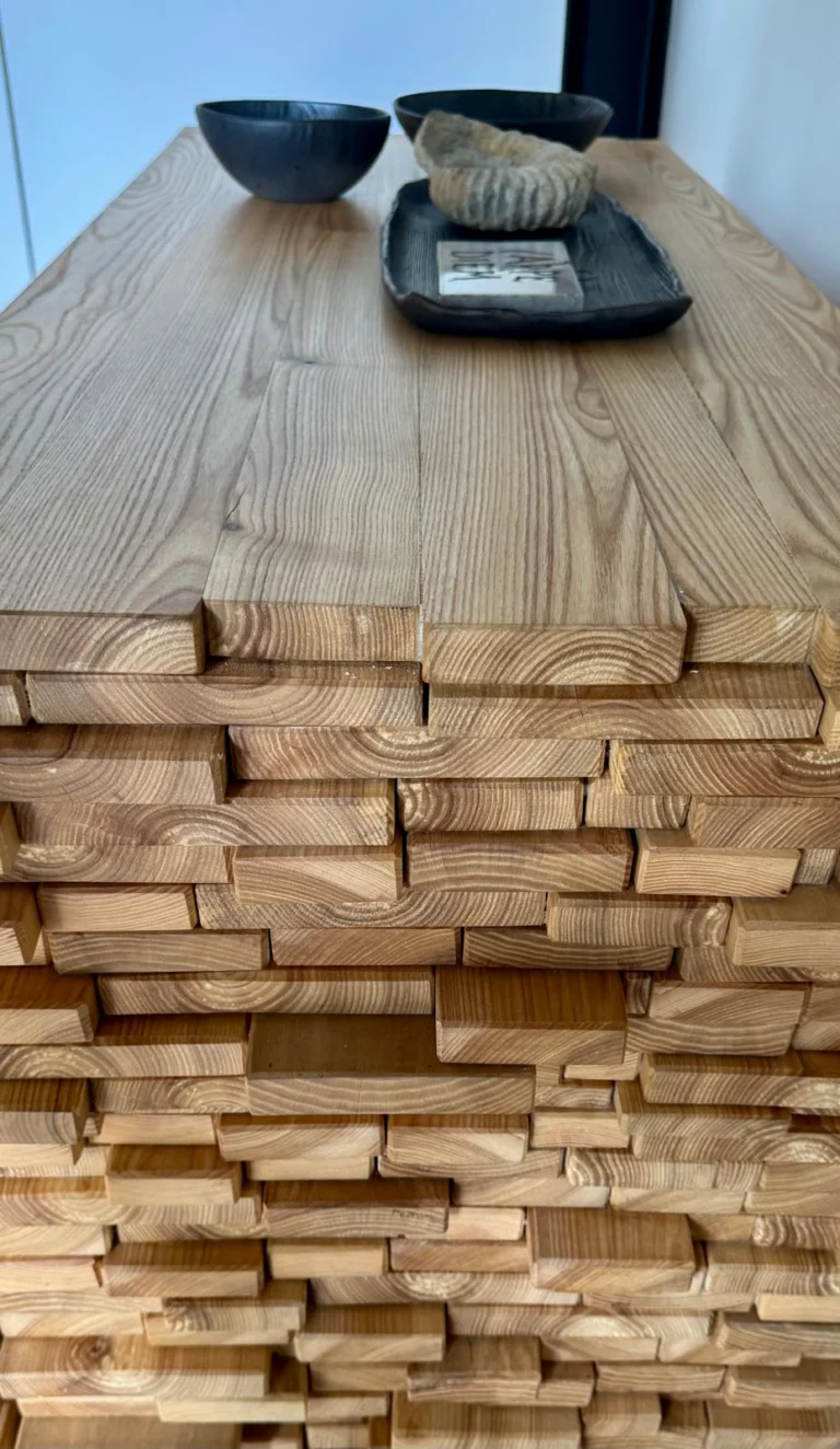The console’s staggered timber edges introduce a tactile, sculptural detail against the loft’s precise metal lines
