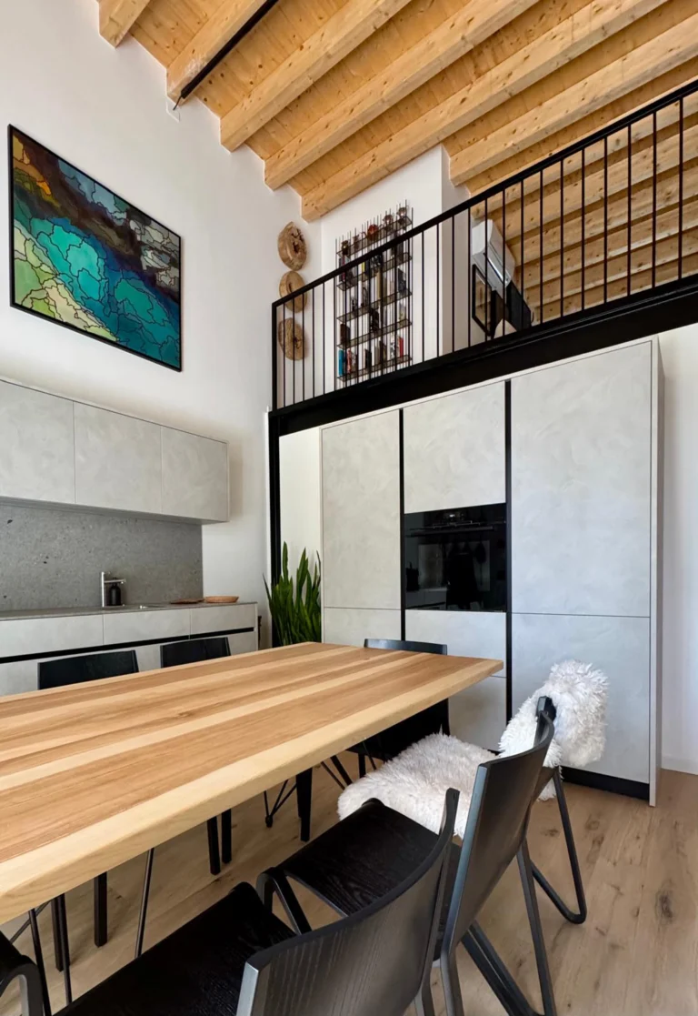 The Cut kitchen provides a quiet backdrop to the dining area, balancing pale cabinetry with timber and black steel.